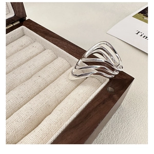 Close-up of S925 sterling silver multilayer wavy ring on a wooden jewelry box