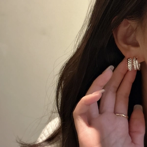 Élégantes boucles d'oreilles créoles torsadées en argent S925 portées par un mannequin