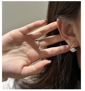 Vue détaillée du clip d'oreille en argent S925 avec perle et bague en argent minimaliste