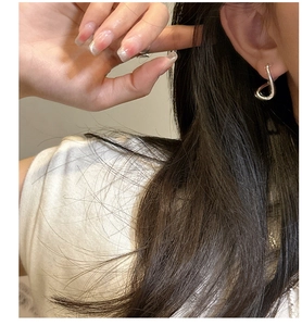 Detail of twisted 925 sterling silver hoop earring shown on ear for minimalist style