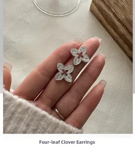 Gros plan des boucles d'oreilles trèfle à quatre feuilles en argent S925 gravé