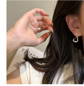 Polished 925 sterling silver twisted hoop earring and matching ring set on a model