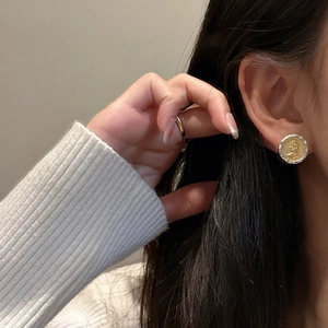 Vintage S925 silver and gold coin stud earrings with Queen relief on a female model