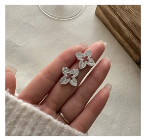 Gros plan de boucles d'oreilles trèfle en argent S925 avec textures spirales détaillées