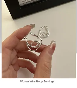 Detailed view of S925 sterling silver knotted hoop earrings with polished metal finish