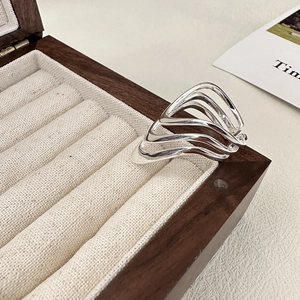Polished silver multi-layer wavy ring with a minimalist 3D hollow design on a jewelry box