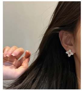 Détail d'une boucle d'oreille trèfle en argent S925 avec gemme rouge et motif gravé