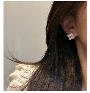 Détail de la boucle d'oreille fleur à quatre pétales en argent S925 sur un mannequin