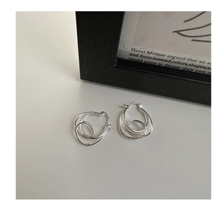 Detailed view of S925 sterling silver knot earrings with engraved hallmark on grey surface