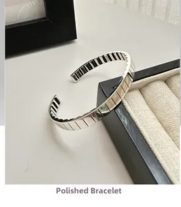 Detailed view of the S925 sterling silver cuff bangle featuring a polished watchband texture