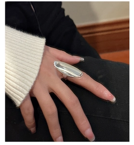Detail of a wide polished S925 sterling silver oval ring on model's index finger