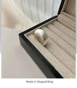 Detail of matte brushed S925 sterling silver open C-shaped ring on jewelry box