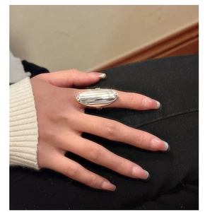 Macro detail of a polished silver S925 oval ring featuring a smooth engraved top surface