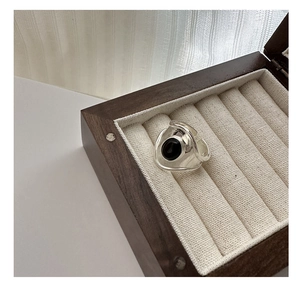 Detail view of oval black onyx S925 sterling silver wide ring on linen jewelry box