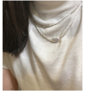 Close-up of elegant S925 silver necklace with baroque pearl on a woman's neck