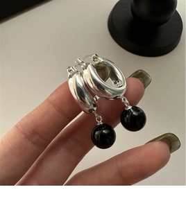Gros plan de boucles d'oreilles en argent 925 avec perles d'agate noire sur anneau épais
