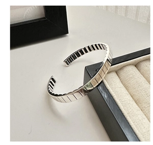 Detailed close-up of S925 sterling silver open bangle with vertical gear-like stripes