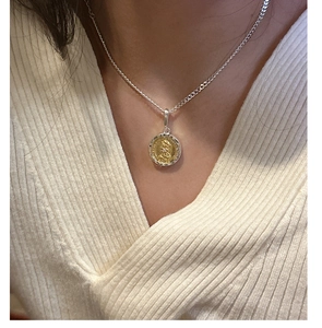 Close-up of S925 silver coin pendant with gold embossed portrait on model's neck
