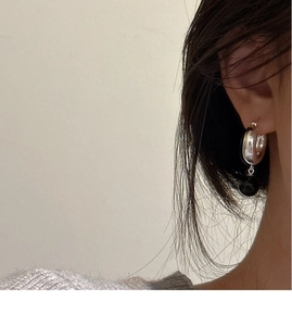 Gros plan de créoles en argent sterling 925 avec perle d'onyx noire sur un mannequin