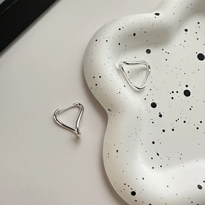 Polished 925 sterling silver twisted wave earrings on a decorative ceramic tray