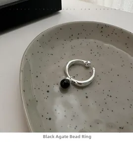 Detail of 925 silver ring featuring a round black onyx bead on a ceramic dish