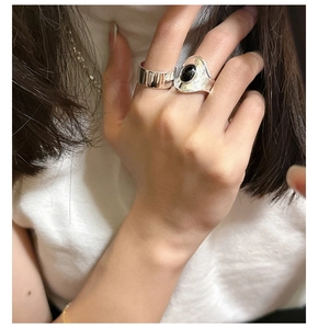 Detail view of a S925 silver wide band and wavy ring set with oval black onyx gemstone