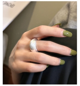 Detail of minimalist wide brushed S925 silver ring with matte texture on finger