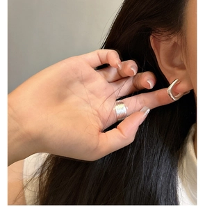 Vue macro des boucles d'oreilles en U et bague large en argent 925 brossé minimaliste