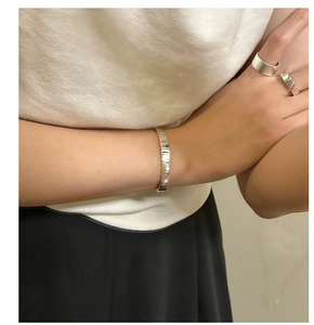Detail of vintage textured S925 sterling silver gear bangle and minimalist rings set