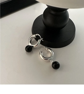 Détail de boucles d'oreilles créoles en argent 925 avec pendentifs perles d'onyx noir
