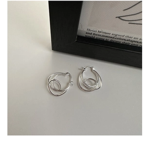 Macro shot of S925 sterling silver knot earrings showing the engraved S925 hallmark