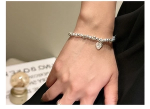 Close-up of S925 sterling silver beaded bracelet featuring heart charm with Be Mine engraving