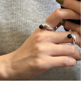 Detailed view of 925 sterling silver ring with black onyx bead on a model's hand
