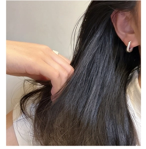 Gros plan de boucles d'oreilles créoles carrées en argent S925 portées par un mannequin