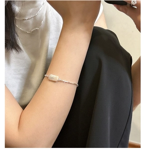 Detailed close-up of a minimalist 925 silver bracelet featuring a rectangular baroque pearl