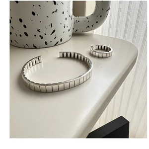 Detailed close-up of S925 sterling silver gear textured bangle and matching ring set