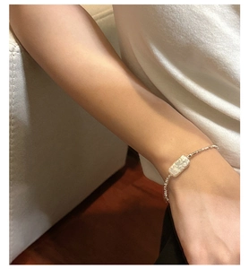 Detail of 925 sterling silver chain bracelet with rectangular shell inlay on wrist