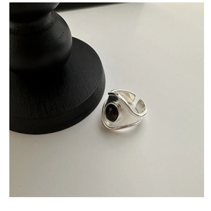 Macro shot of S925 silver ring featuring wide oval black agate stone and irregular band