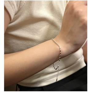 Macro shot of minimalist S925 sterling silver rice bead bracelet on model's wrist