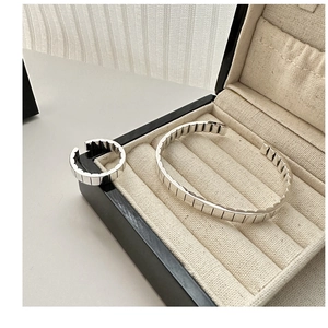 Detailed view of S925 sterling silver gear-textured open bangle and matching ring in a box