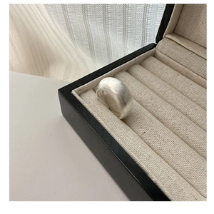 Detailed macro view of wide matte brushed S925 sterling silver ring in jewelry box