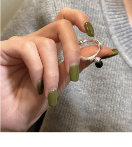 Detail of silver ear cuff featuring a round black onyx bead on a minimalist open ring