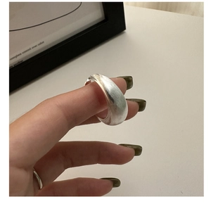 Close-up of matte silver wide band ring with minimalist brushed texture on the index finger