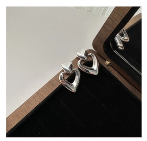 Detailed view of S925 sterling silver double-layered heart earrings on black jewelry box velvet