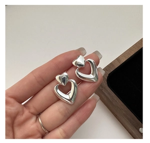 Detail of S925 silver double heart earrings with a nested polished and hollow design