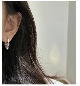 Gros plan des boucles d'oreilles cœur en argent S925 avec finition texturée