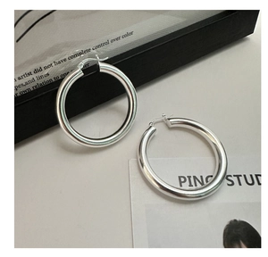 Macro shot of S925 sterling silver hoop earrings with polished finish and logo stamp