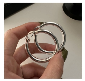 Detail view of large S925 sterling silver hoop earrings with polished mirror finish
