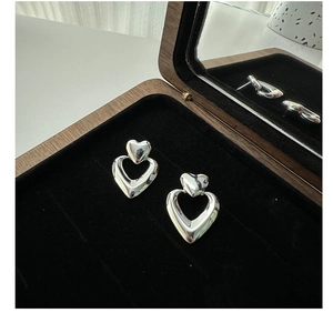 Macro view of S925 sterling silver double heart earrings on black velvet lining