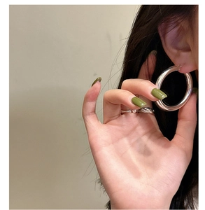 Close-up of stylish S925 sterling silver hoop earrings and minimalist ring worn by a model